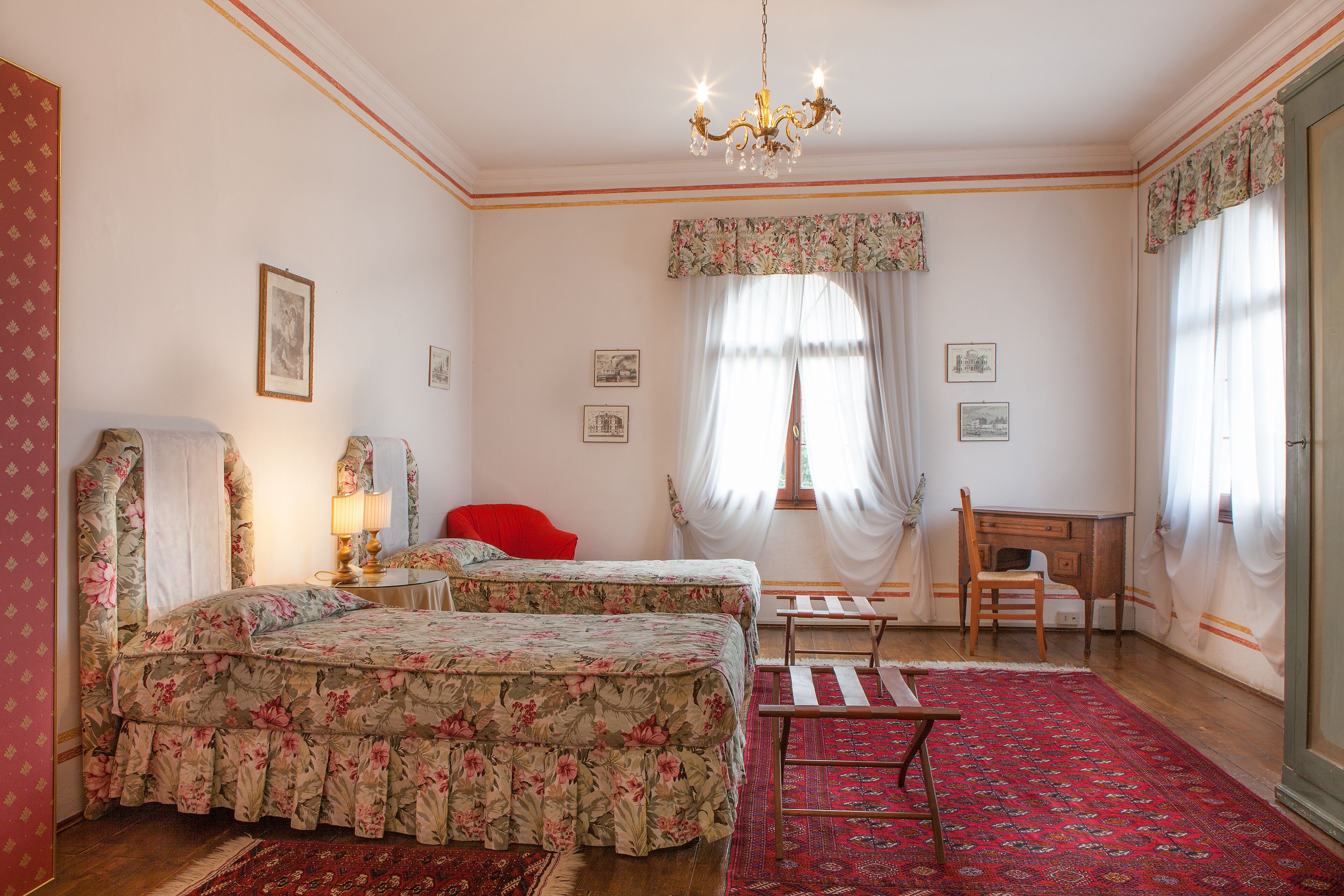 Un dormitorio con una cama doble, un escritorio, una silla y un sillón rojo.
