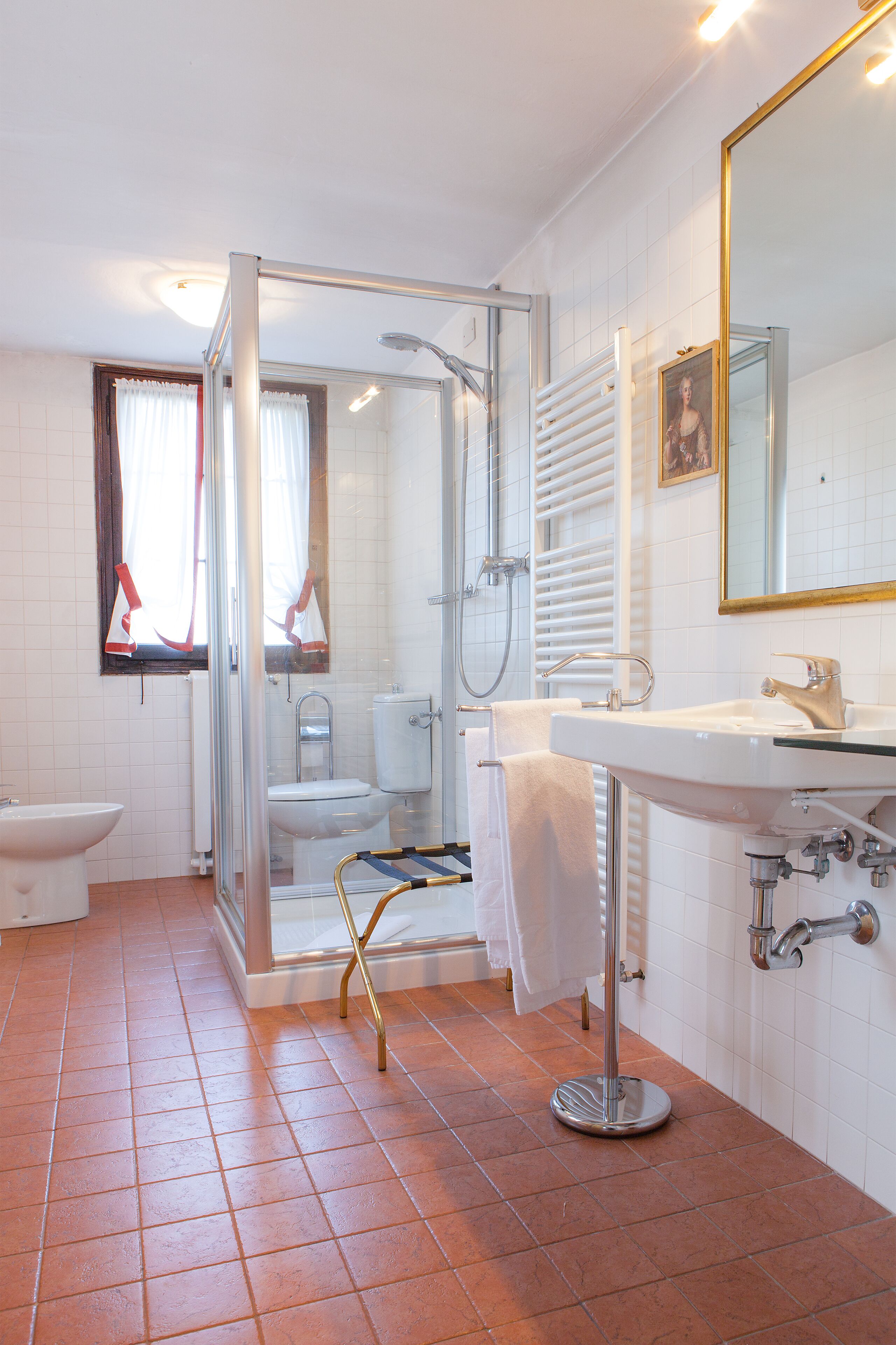 Un bany amb una dutxa de vidre, un lavabo i un vàter.