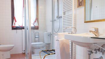 Un bany amb una dutxa de vidre, un lavabo i un vàter.