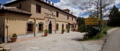 A traditional building with a sign indicating the direction to Hotel Abaceria and a restaurant.