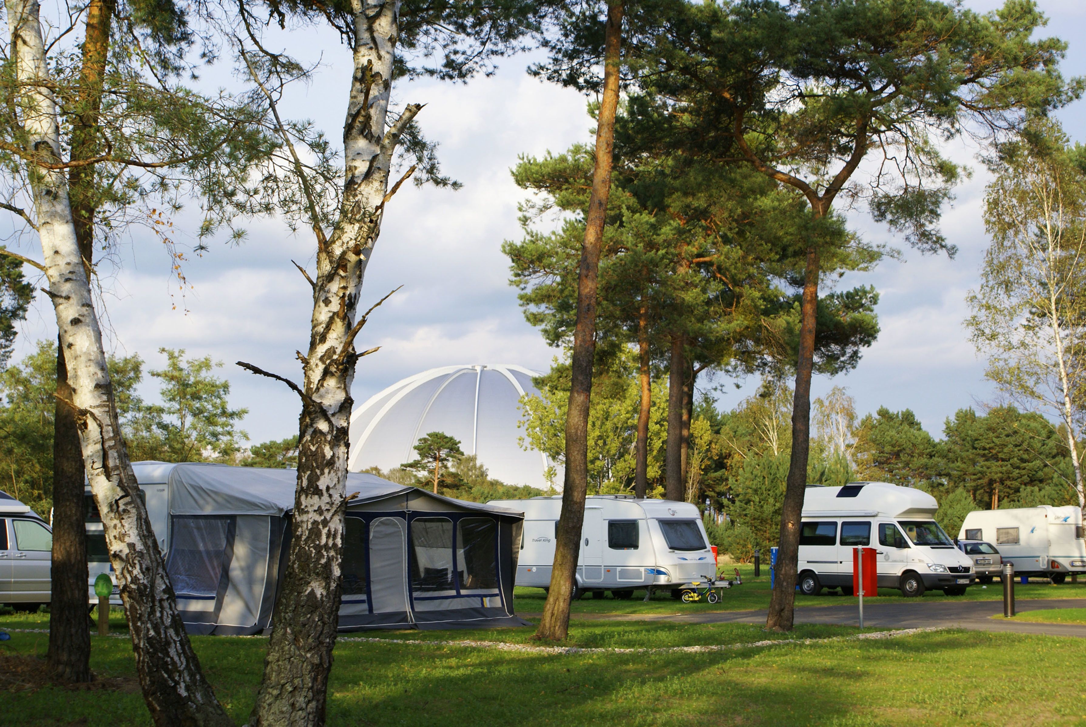 A campsite with RVs, a tent, and a large dome structure.