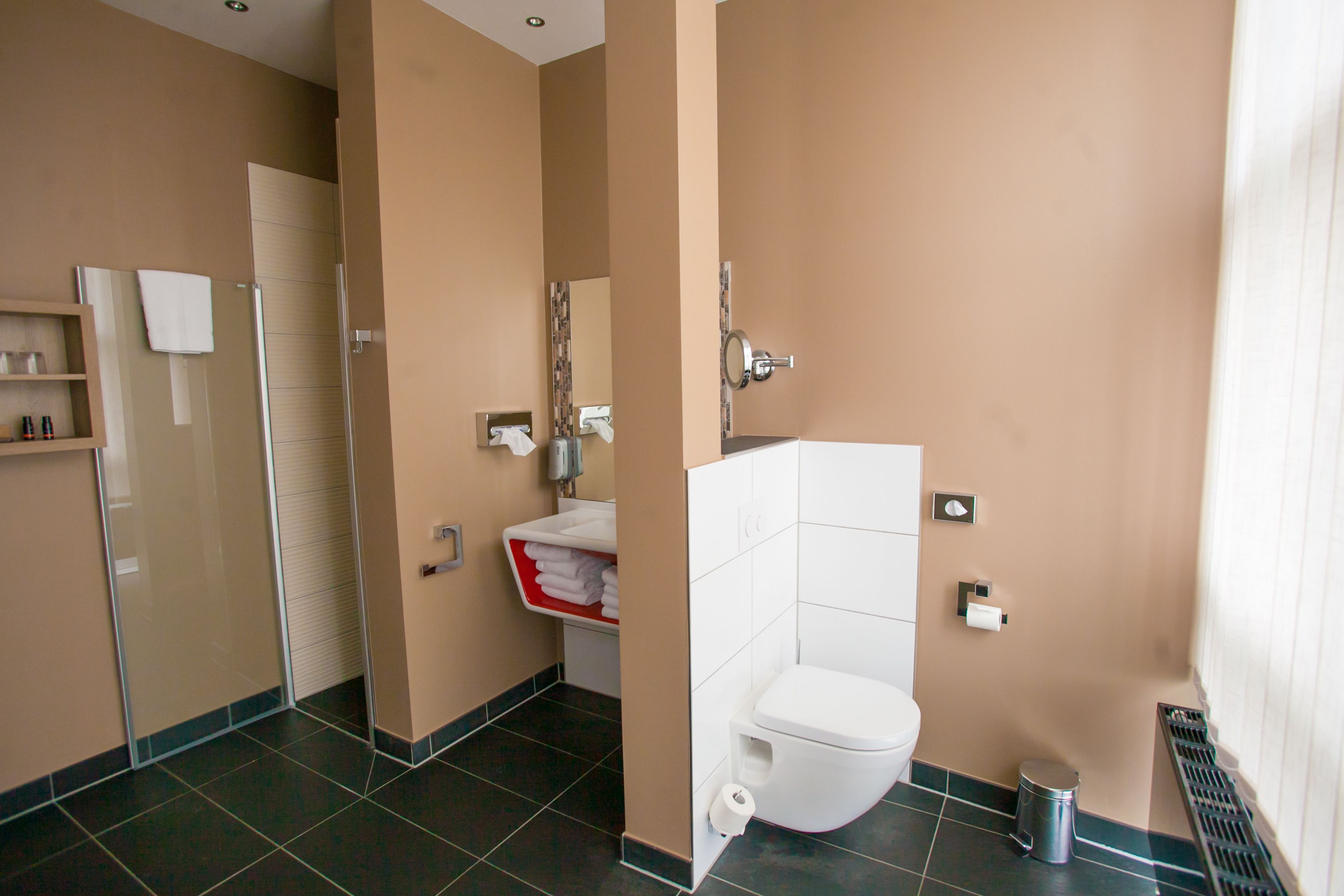 Une salle de bain moderne équipée de toilettes, d’un lavabo et d’un espace douche.