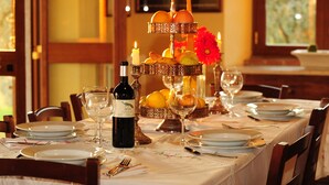 Une table à manger dressée avec des assiettes, des verres à vin et une bougie.
