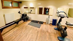 A gym with exercise equipment, a mirror, and a radiator. - Marmore (Cervinia)