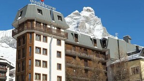 A hotel with a modern design, featuring balconies and a view of snow-capped mountains. - Marmore (Cervinia)