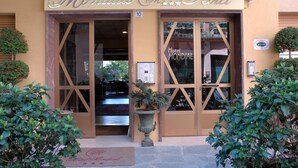 The exterior of Mondial Hotel with a large entrance, a reception area visible inside, and a decorative plant in front. - Hotel Mondial (Rapallo)