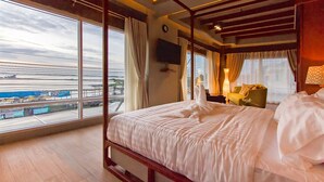 Een hotelkamer met een groot bed, een televisie en uitzicht op het vliegveld.
