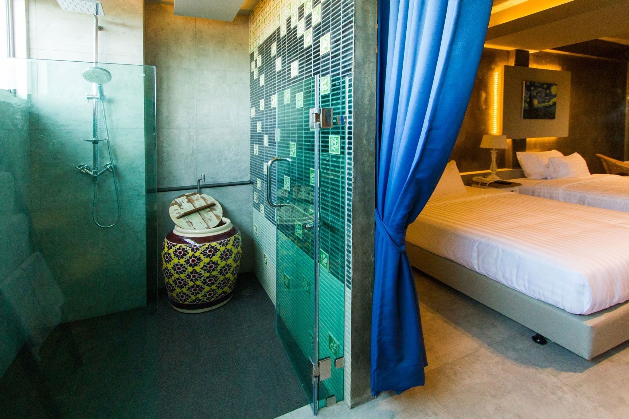 Una camera d'albergo con doccia, un water, un letto e un piccolo oggetto decorativo.