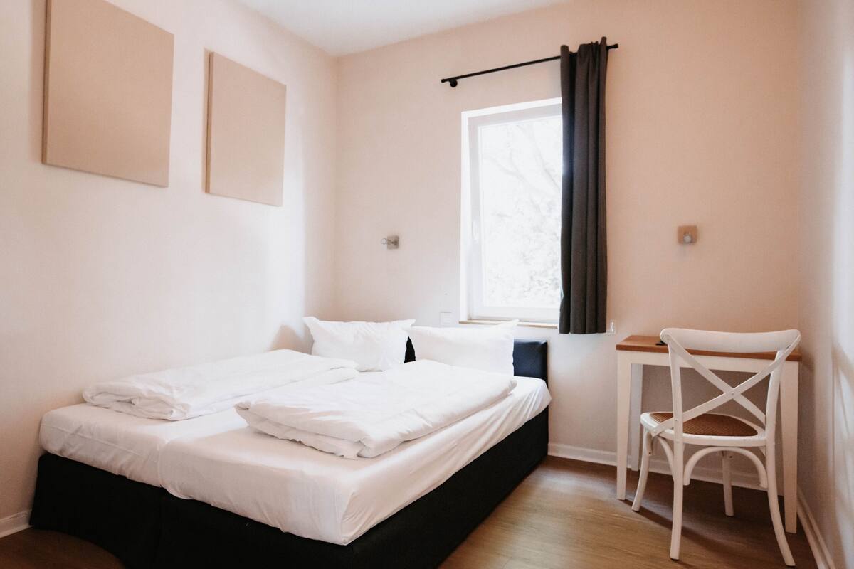 Un dormitorio con cama, escritorio y silla.