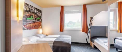 Habitación de hotel con dos camas, un escritorio, una silla, un televisor y una ventana con cortinas.