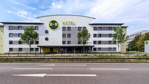 A modern B&B hotel with a curved facade, multiple windows, and a central entrance. - B&B Hotel Augsburg-Süd (Augsburg)