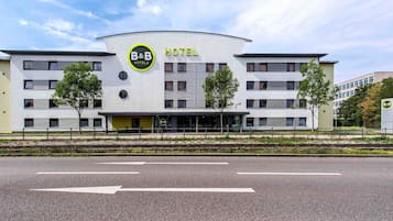 Een modern bed en breakfast hotel met een gebogen gevel, meerdere ramen en een centrale ingang.
