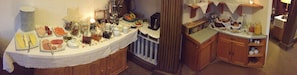 A buffet setup with various food items and utensils. - Gästehaus Hohe Tannen (Garmisch-Partenkirchen)