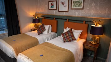 A hotel room with two beds, each with a headboard, bedside tables with lamps, and a window with curtains.
