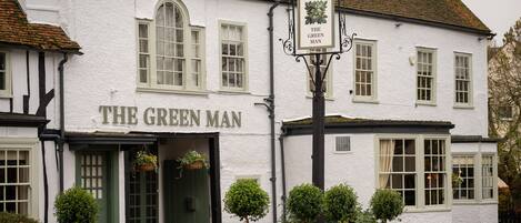 A white building with a sign reading "The Green Man" and a pub sign above the entrance.