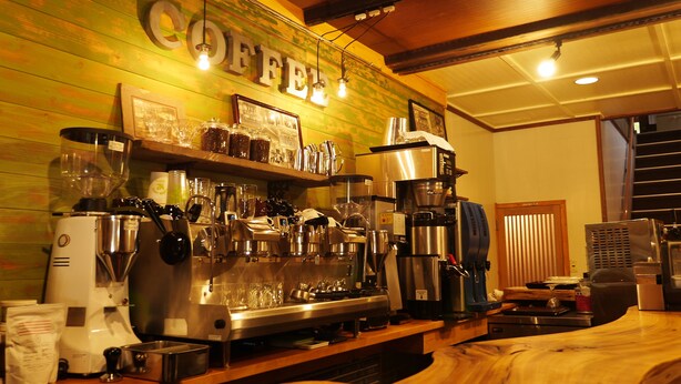 En kaffebar med forskelligt kaffebrygningsudstyr, et skilt med teksten "COFFEE" og en trædisk.