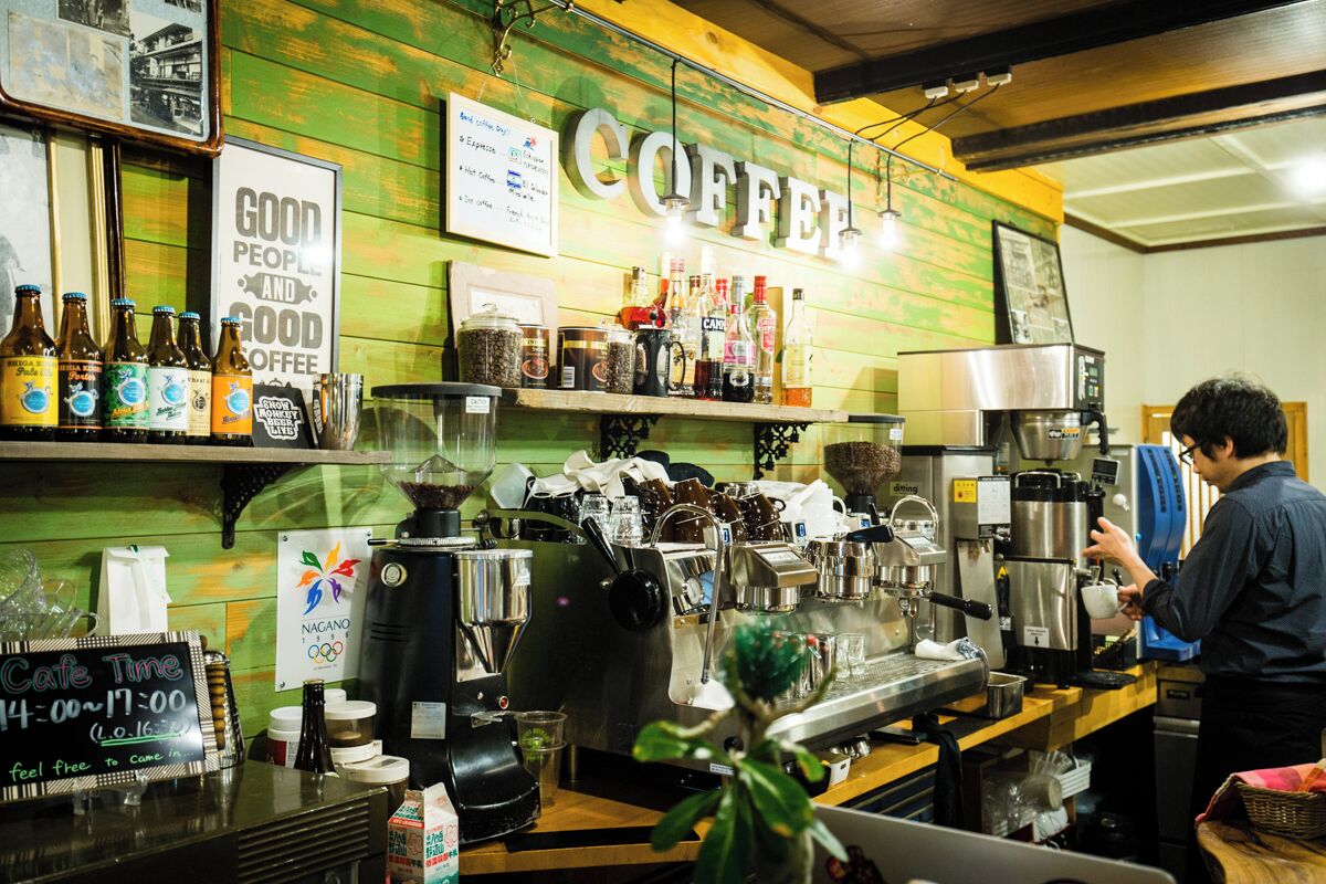 A coffee shop interior with a counter, coffee machines, and various coffee-related items on display.
