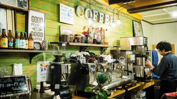A coffee shop interior with a counter, coffee machines, and various coffee-related items on display.