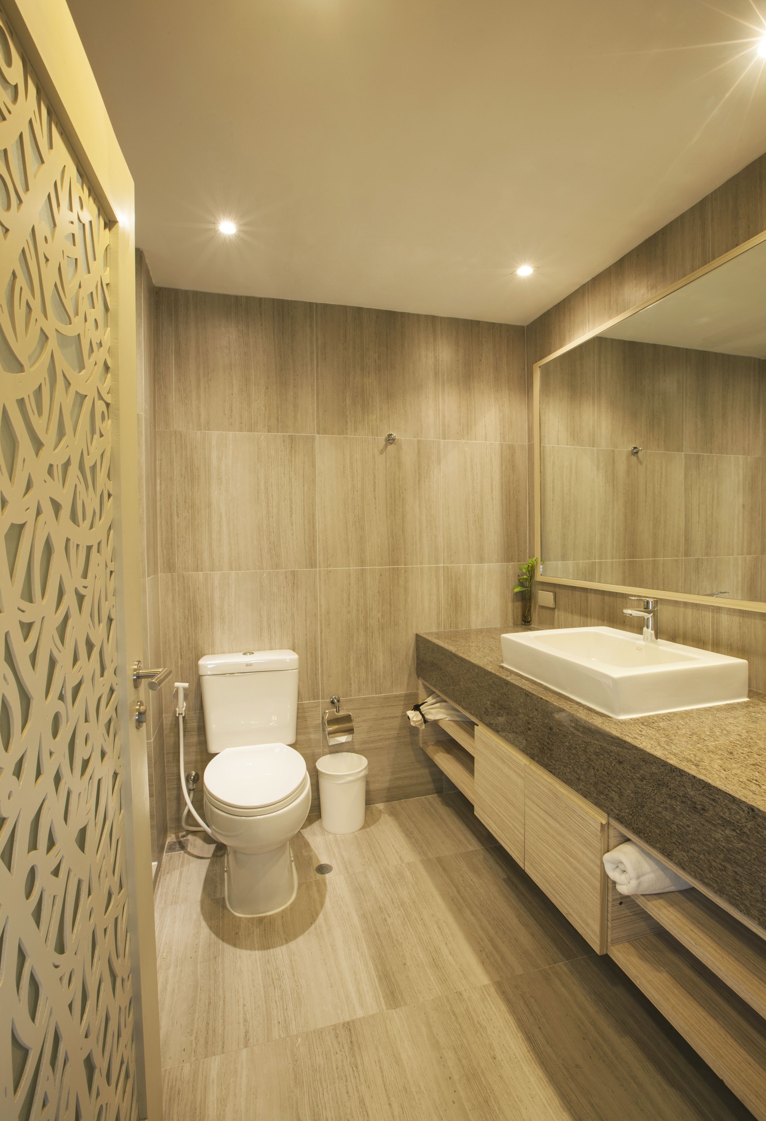 A modern bathroom with a toilet, sink, and mirror.