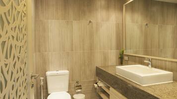A modern bathroom with a toilet, sink, and mirror.