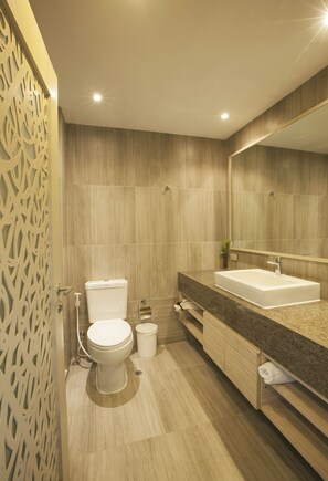 Een moderne badkamer met toilet, wastafel en spiegel.