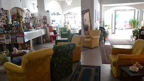 Amplia sala de estar con diversas opciones de asientos, una zona de bar y vistas a la calle.