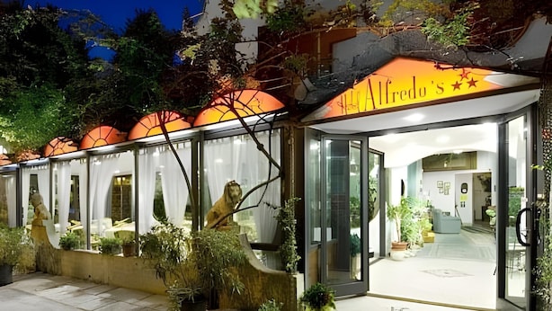 Un edificio con fachada de vidrio, un letrero que dice 'The Redo's' y una estatua de león en el exterior.