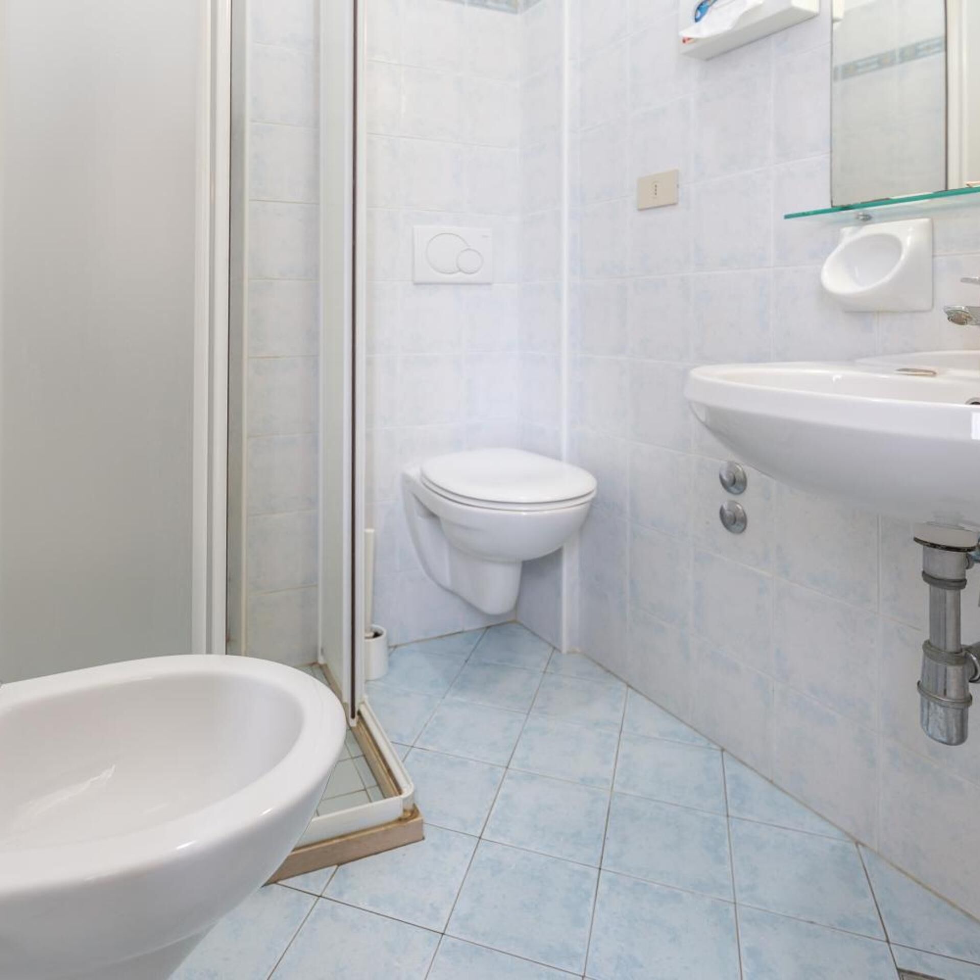 A bathroom with a toilet, a sink, and a glass shower enclosure.