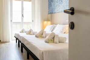 A hotel room with a bed, pillows, and neatly folded towels. - Airone (Rimini)