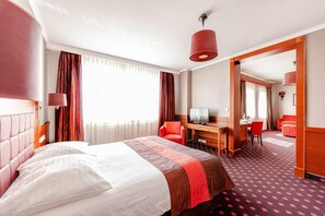 A hotel room with a bed, a desk, a chair, and a television. - Hotel Panorama (Mszczonow)
