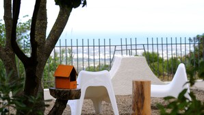 A playground with a slide, a white plastic chair, and a bird feeder. - B&B Puglia Vista Mare (Monopoli)