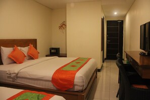 A hotel room with two beds, a desk, a chair, and a television. - Mahatma Residence (Denpasar)