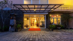 A modern building with a glass entrance, a covered patio area, and potted plants. - Mahatma Residence (Denpasar)