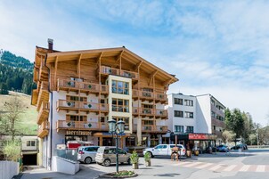Un hotel de varios pisos con balcones, un restaurante y un estacionamiento.