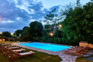 Una piscina al aire libre de temporada, sombrillas, tumbonas