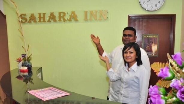 Ein Empfangsschalter mit der Aufschrift "SAHARA INN" und einer Uhr darüber.