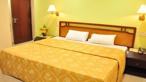 Ein Hotelzimmer mit einem Bett, zwei Nachttischlampen, einem Nachttisch und einer Tür.