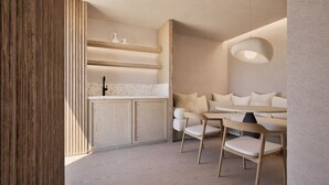 A modern interior with a wooden cabinet, a sink, and a seating area with a table and chairs. - Hotel Pefkos Beach (Rhodes)