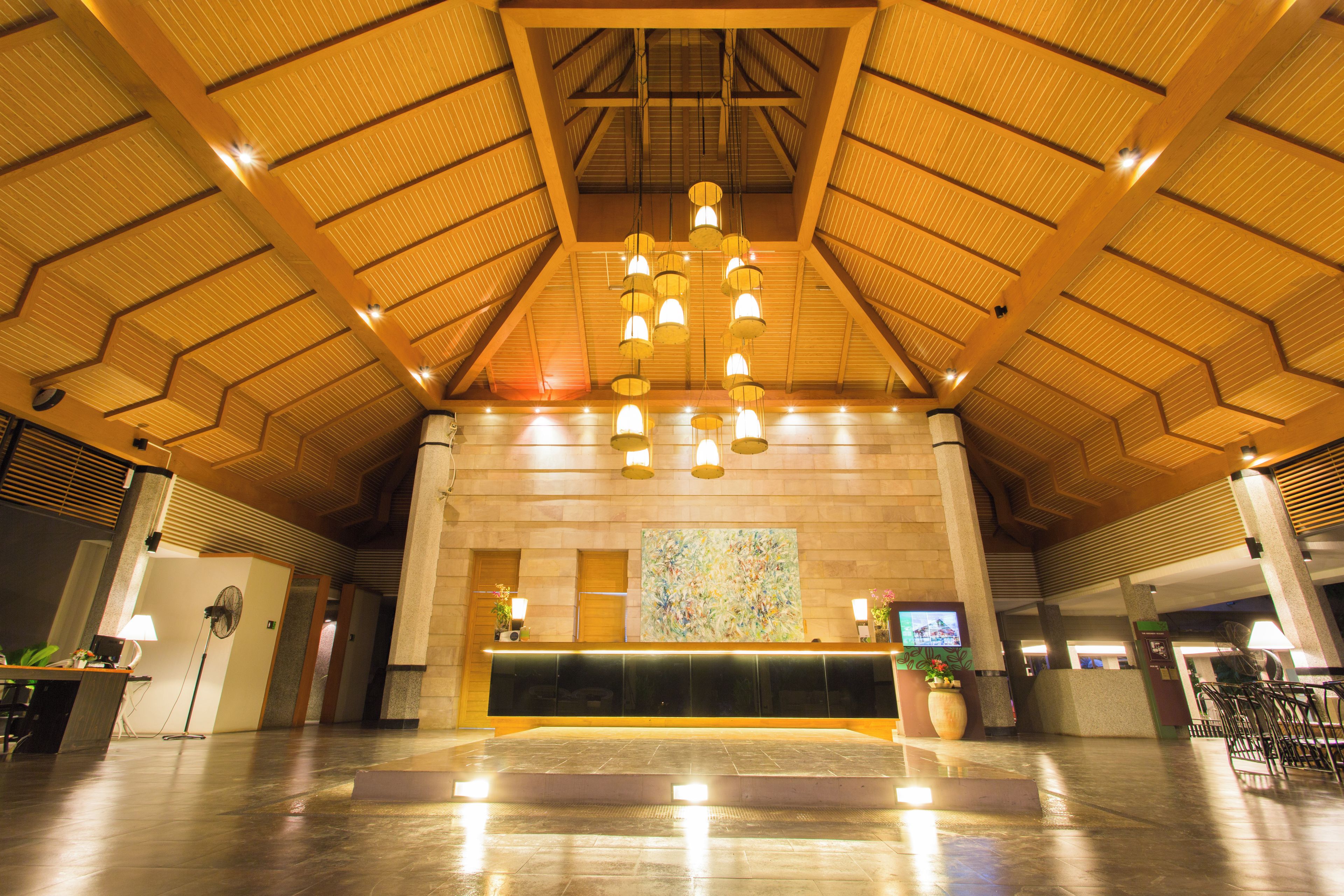 A spacious lobby with a high ceiling and a reception desk.