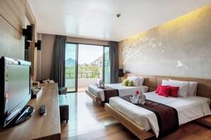 Quarto de hotel com grande janela, televisão de tela plana, duas camas, escrivaninha e varanda.