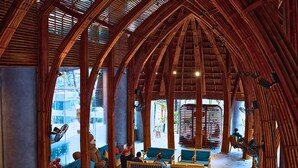 A spacious interior with high bamboo ceilings, comfortable seating areas, and large windows offering views of the outside. - Avatar Danang (Da Nang)