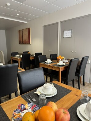 Una sala de conferencias con una mesa de madera, sillas negras y una pizarra.