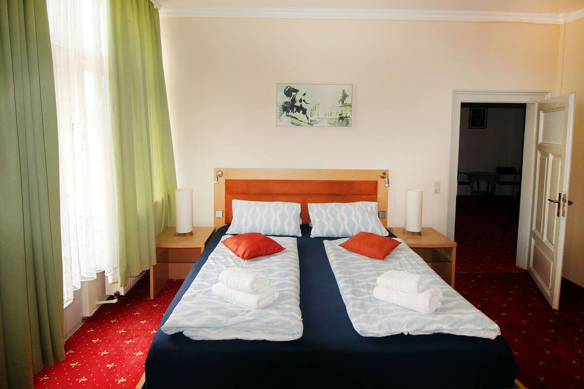 Un lit double avec deux oreillers, une table de chevet, une lampe et un tableau au mur.