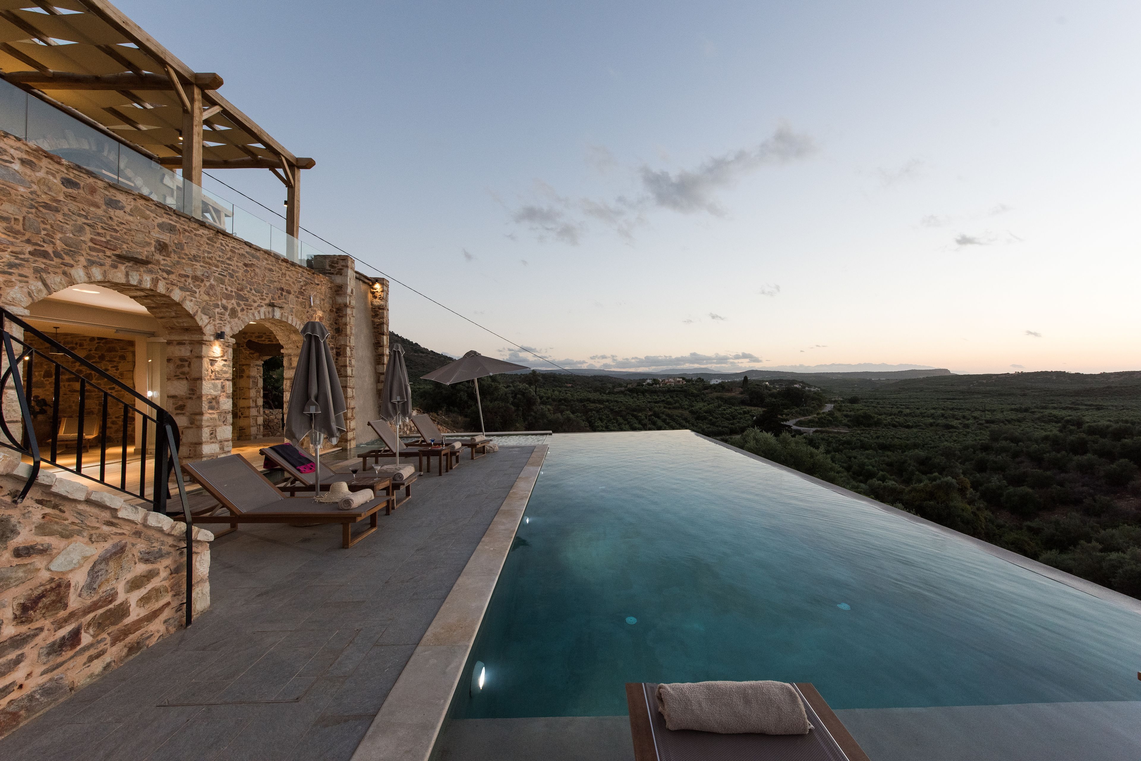 Una piscina infinita con vistas a un paisaje montañoso.