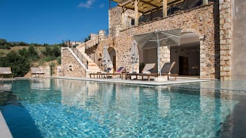 Una piscina al aire libre de temporada, sombrillas