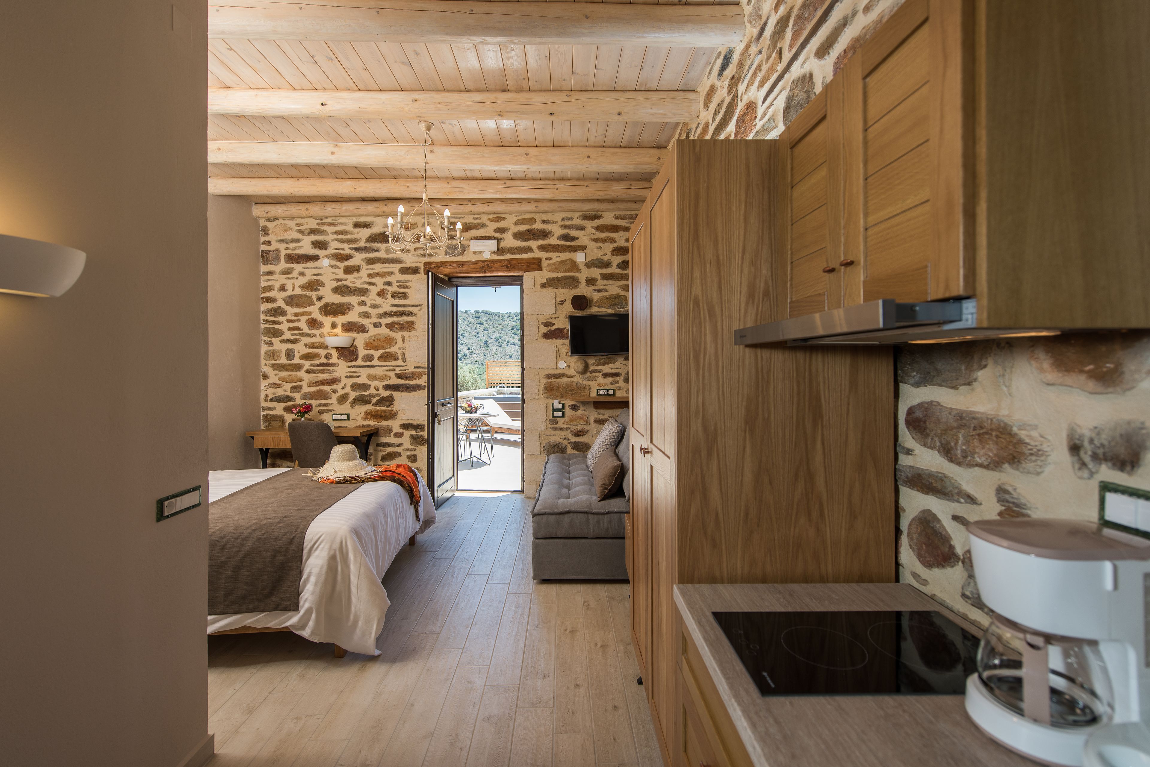 Ein Zimmer mit einem Bett, einem Schreibtisch und einer Steinwand.
