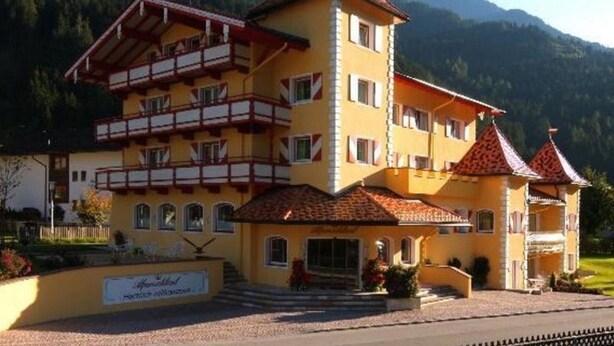 A multi-story hotel with a traditional Alpine architectural style, featuring balconies and a red-tiled roof. - Alpenschlössl (Mayrhofen)