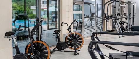 A gym with stationary bikes, a treadmill, and weight machines.