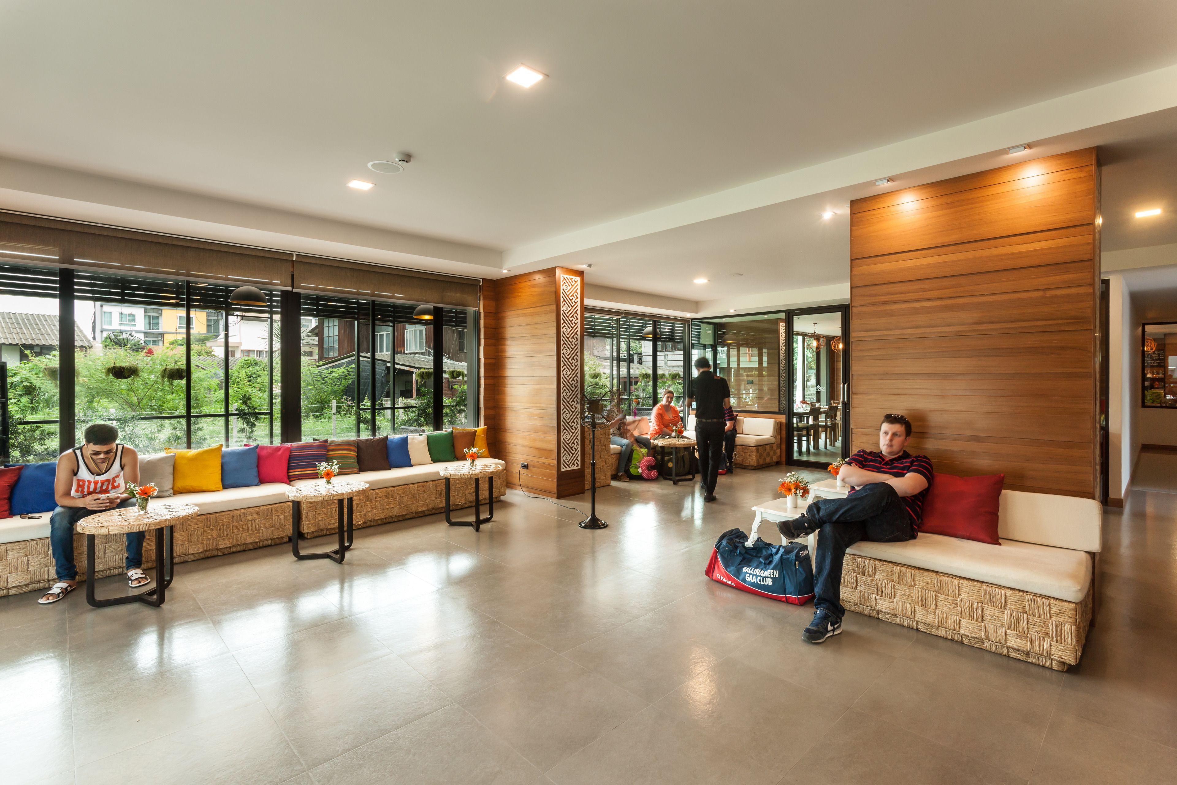 Un hall espacioso con zonas de estar, un mostrador de recepción y amplias ventanas que ofrecen vistas al exterior.