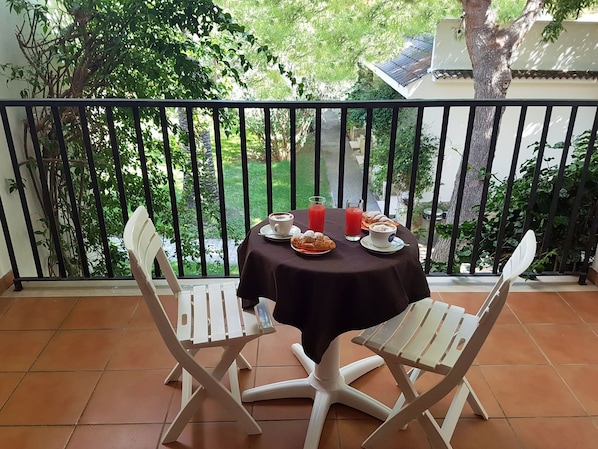 A balcony with a table set for two, featuring a drink, pastries, and a bowl of soup. - Hotel Gabbiano Beach (Vieste)